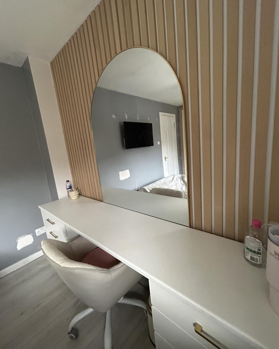 Strip paneling installation behind makeup desk and dresser